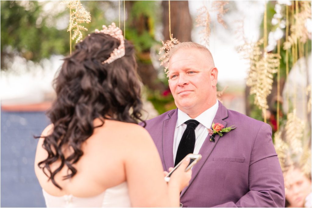 groom listening to bride reading vows