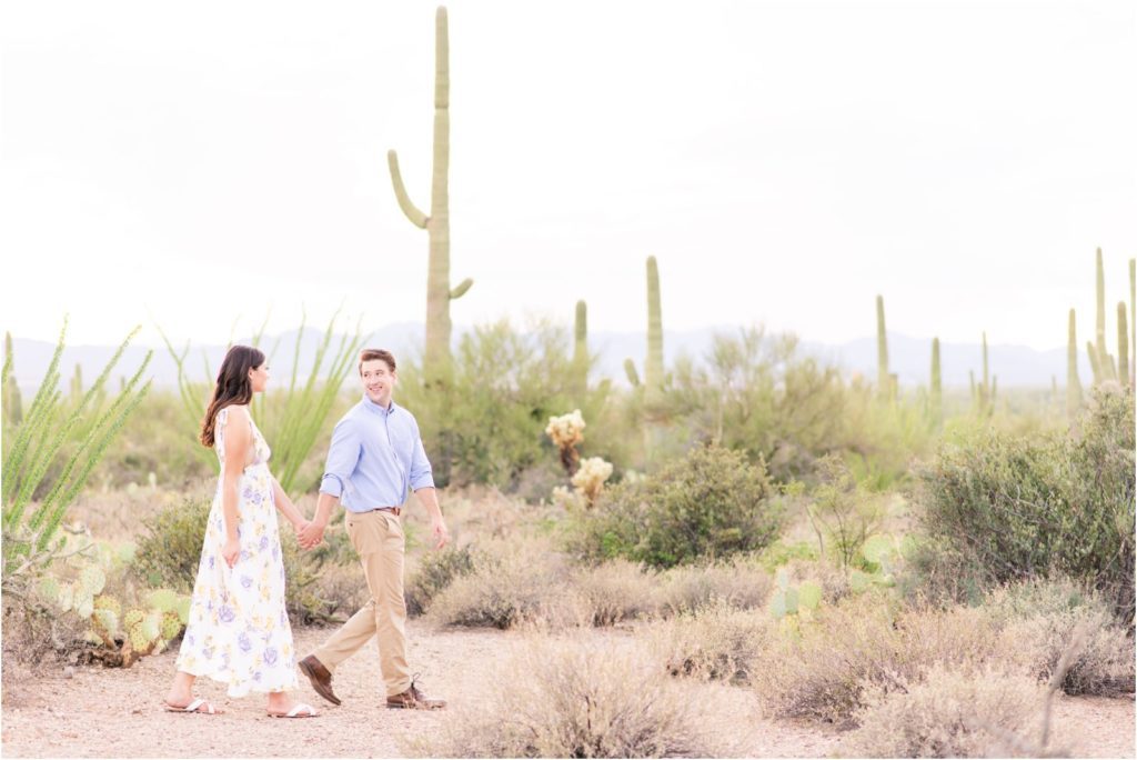 Engaged couple walking in desert