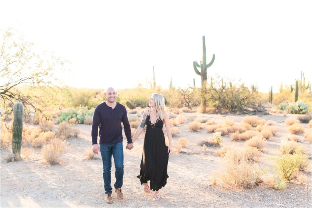 engaged couple walking in the desert by Tucson wedding photographer Christy Hunter Photography