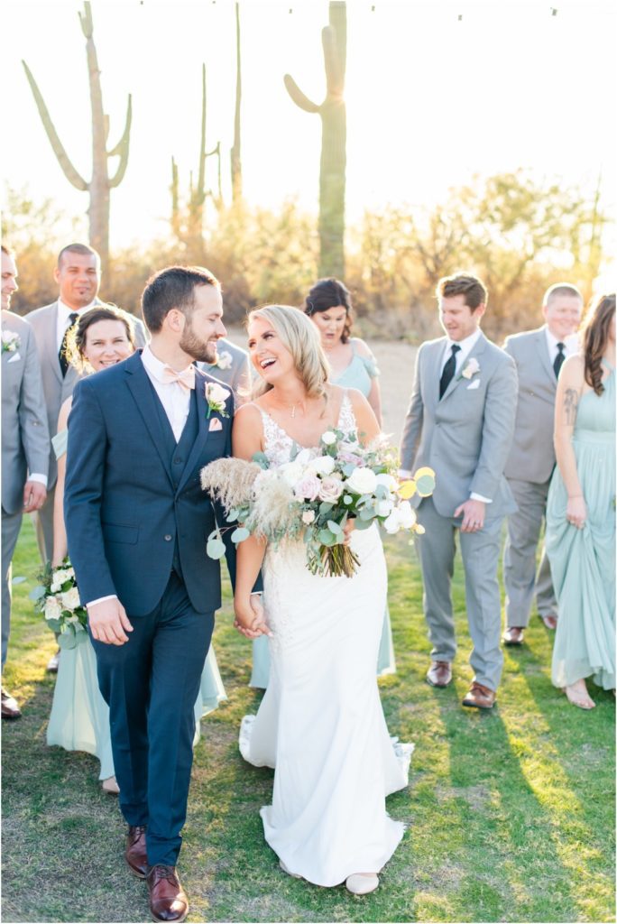 bride and groom walking on lawn at the barn at Tanque Verde Ranch laughing and smiling