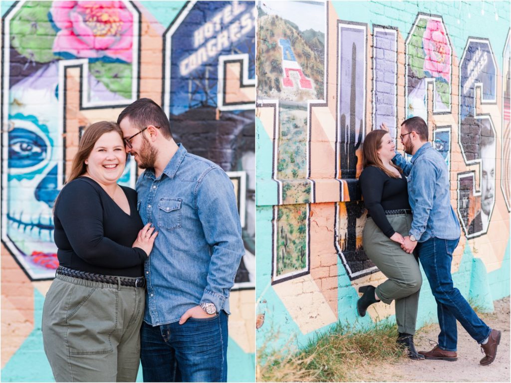 couple smiling and snuggling in front of colorful mural