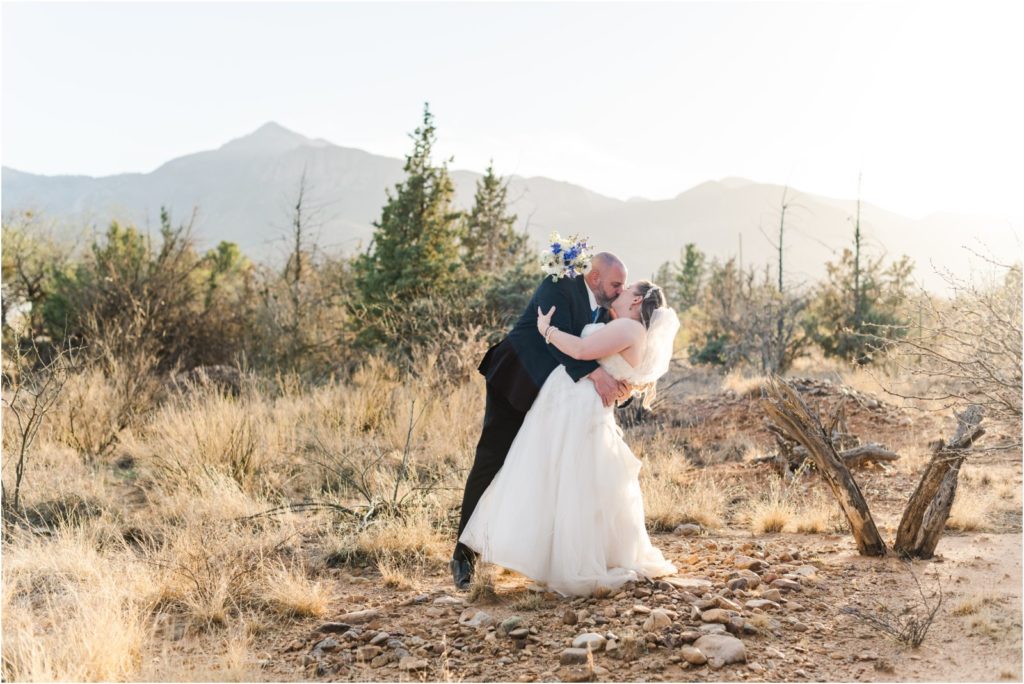bride and groom dip kiss with mountains in background in Hereford AZ wedding