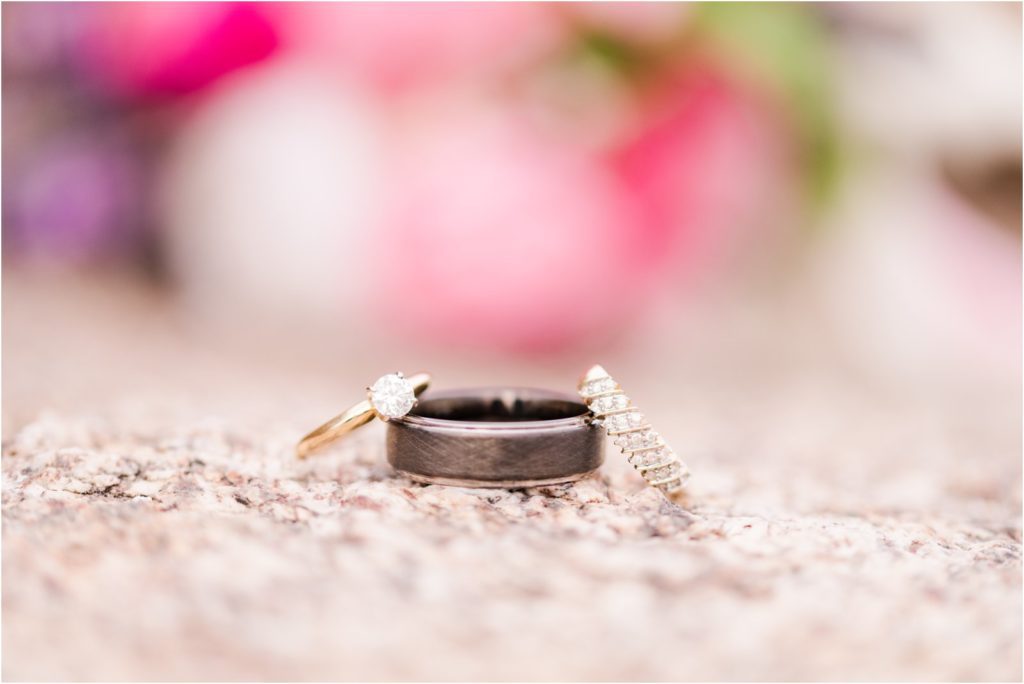 wedding bands on stone with bouquet