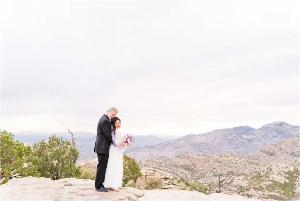 bride and groom holding each other at lookout on Mount Lemmon