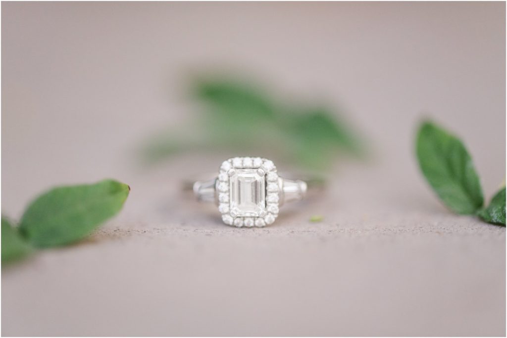 photo of engagement ring on concrete with leaves