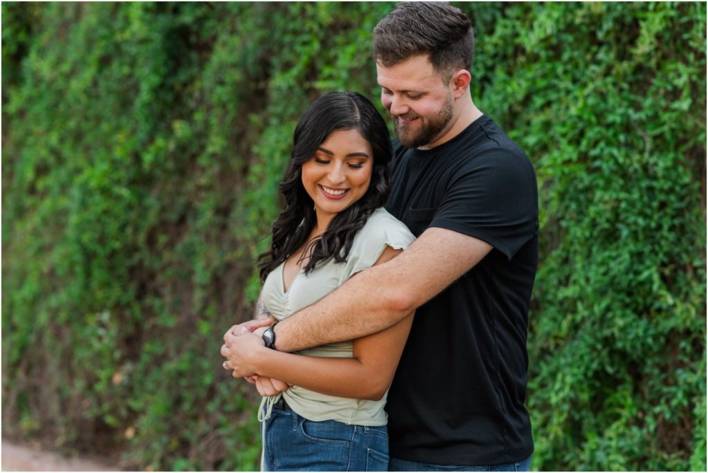 newly engaged couple in Tucson by ivy covered wall