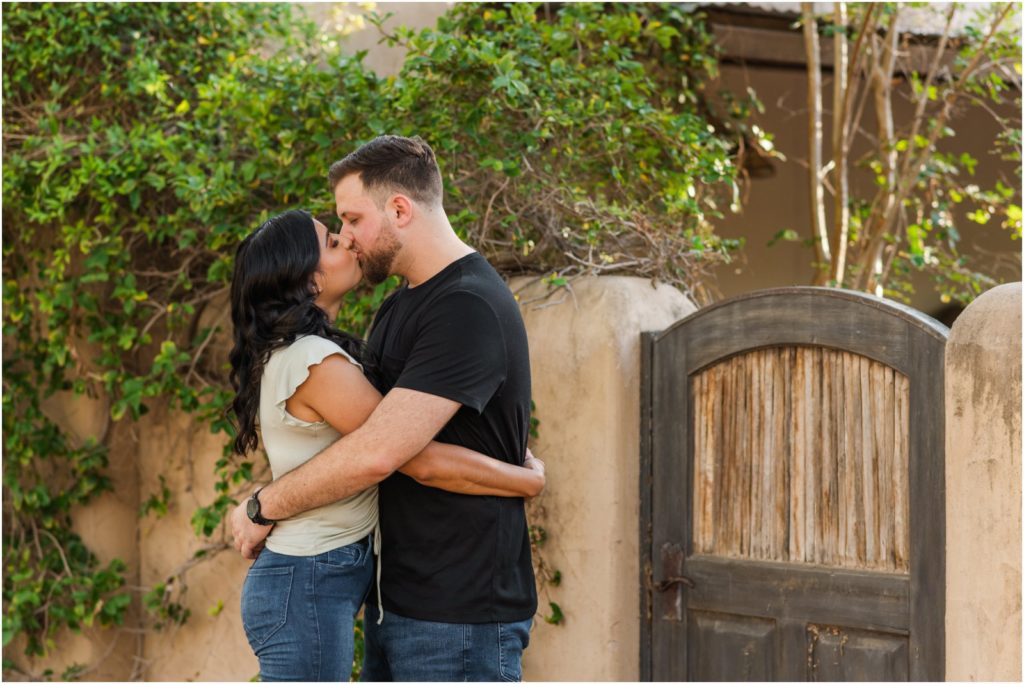 engaged couple hugging my antique door on old ranch estate in Tucson