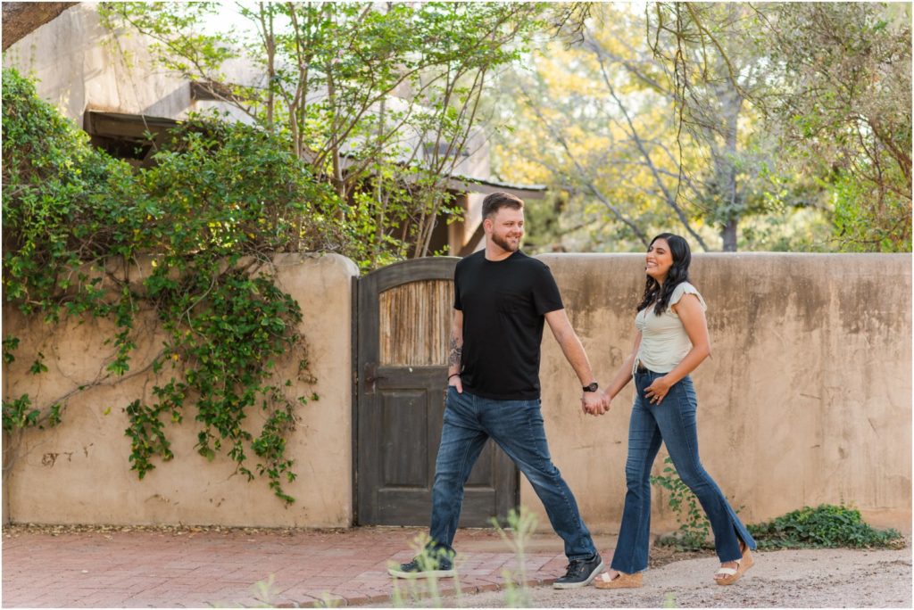 engaged couple holding hands and walking during Catalina Foothills engagement session