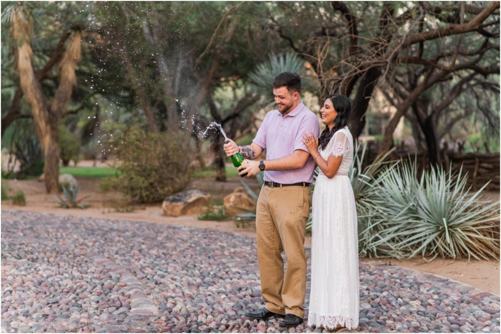couple popping champagne to celebrate engagement in Tucson