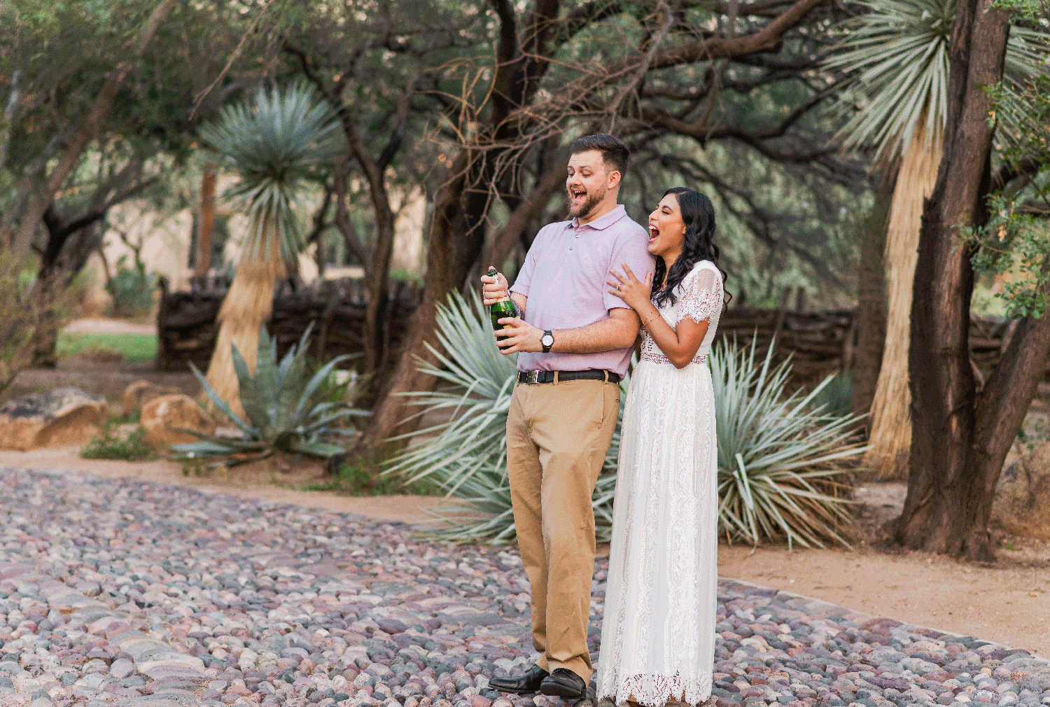 couple popping champagne to celebrate engagement in Tucson