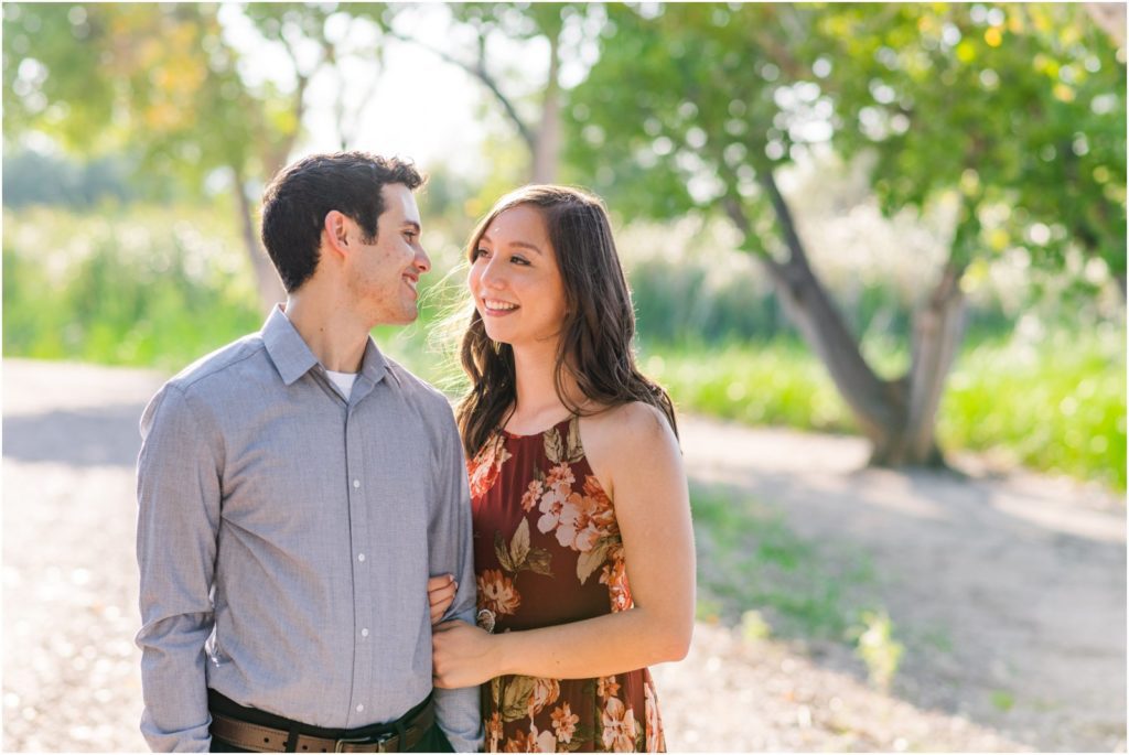 couple smiling at one another during engagement session
