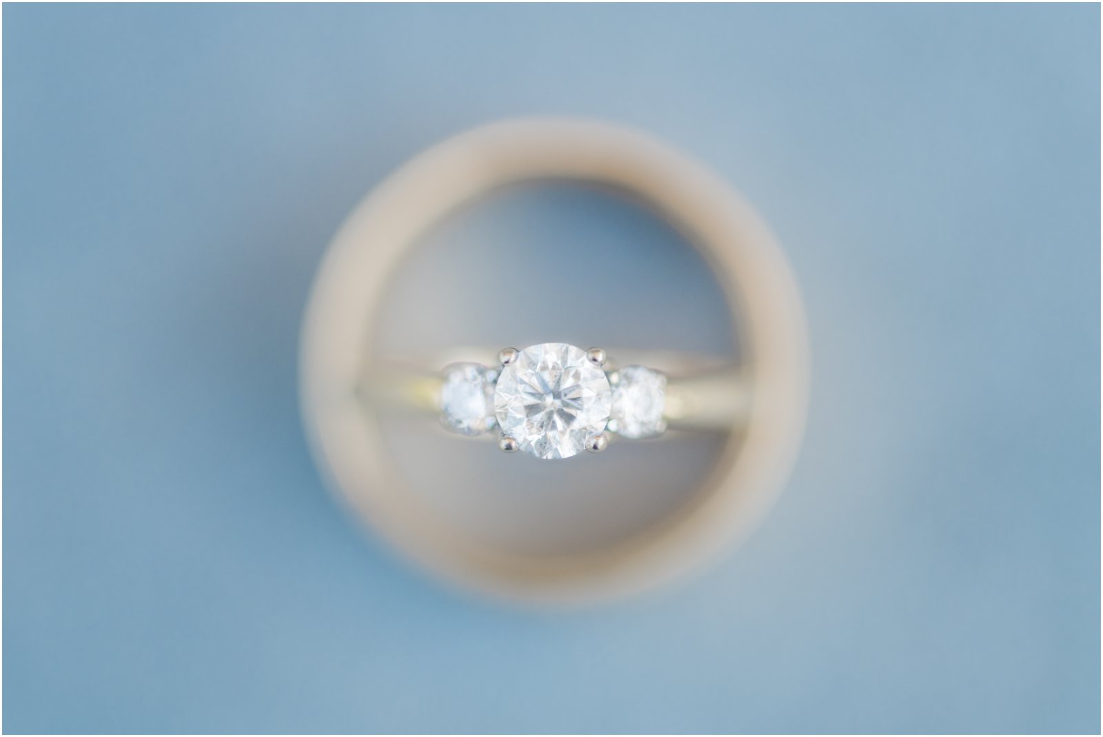 gold wedding band surrounding diamond engagement ring