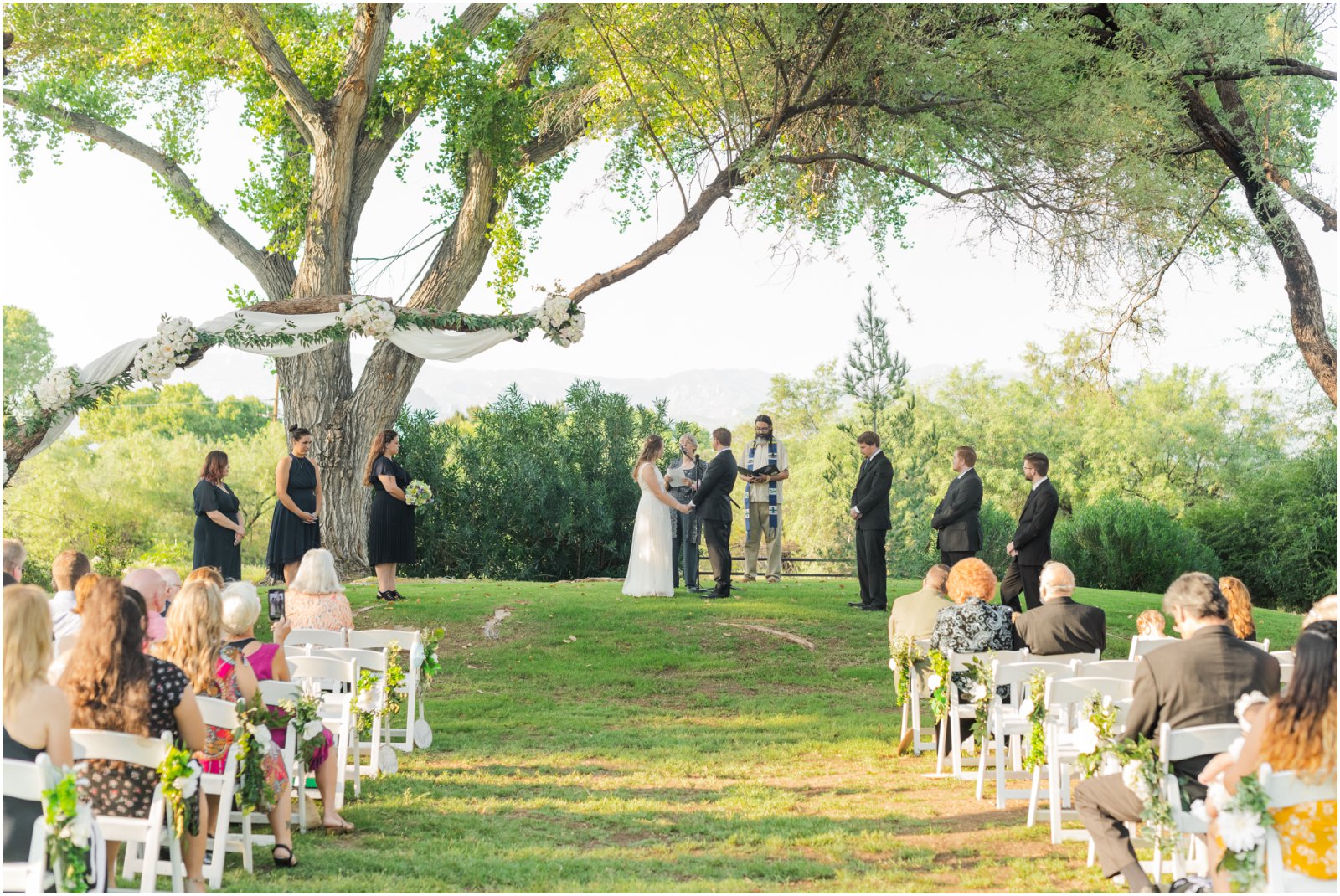 navy and sage green summer wedding outside on the lawn at La Mariposa Tucson