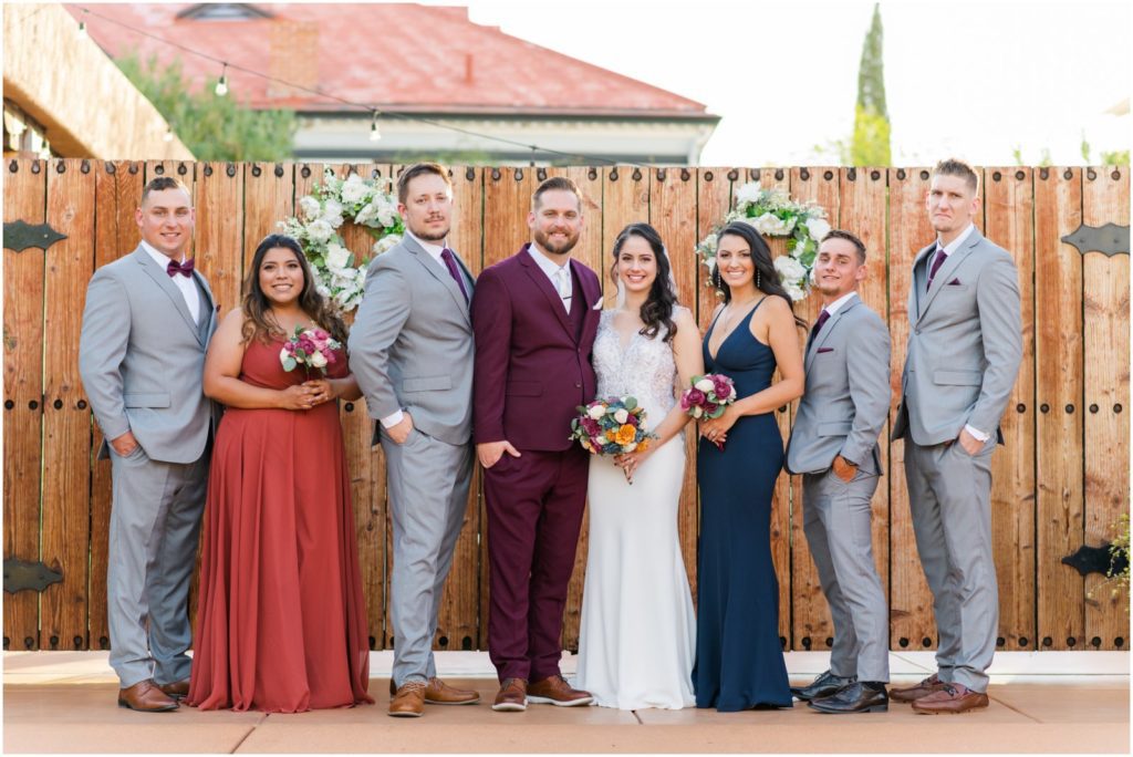bridal party photo in front of wooden gates at the Stillwell House and Gardens wedding venue