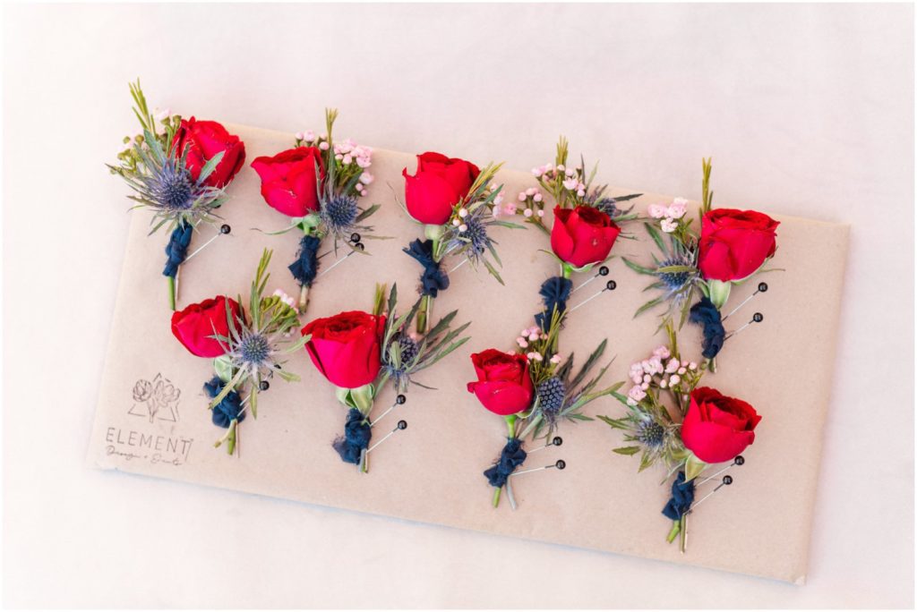 red and navy boutonnieres for groom and groomsmen
