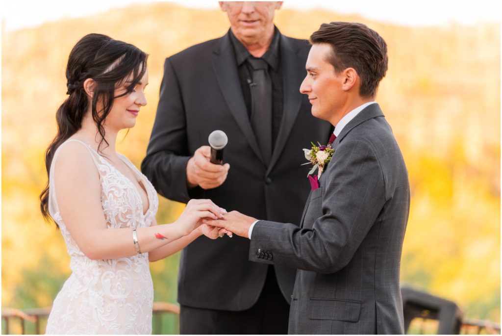 bride and groom exchanging rings during wedding ceremony at Saguaro Buttes