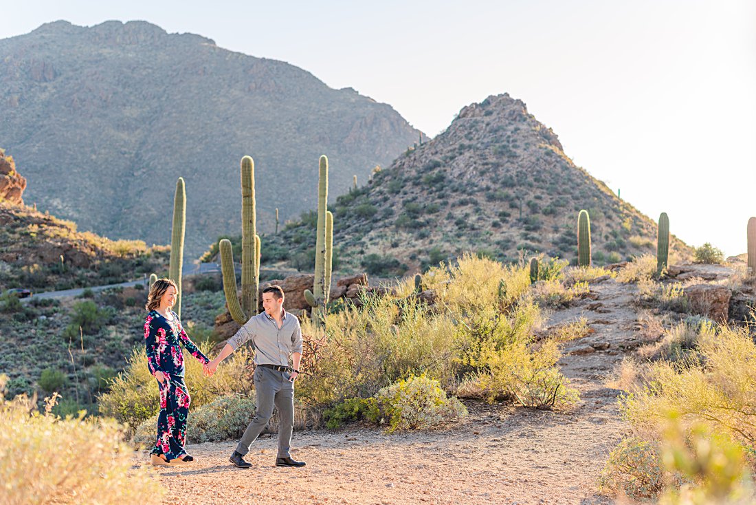 engaged couple walking through desert during Tucson engagement session
