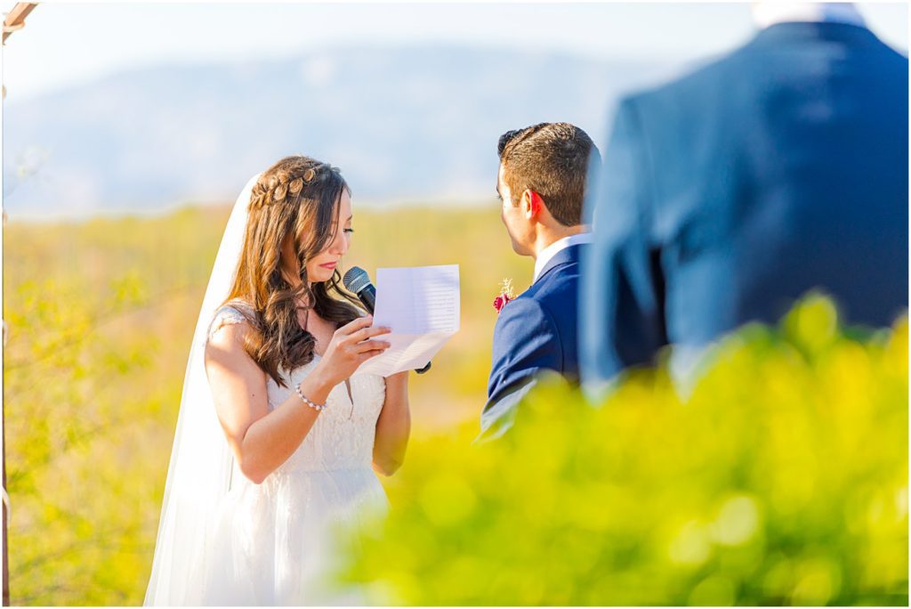 bride starting to cry while reading vows to groom during wedding ceremony
