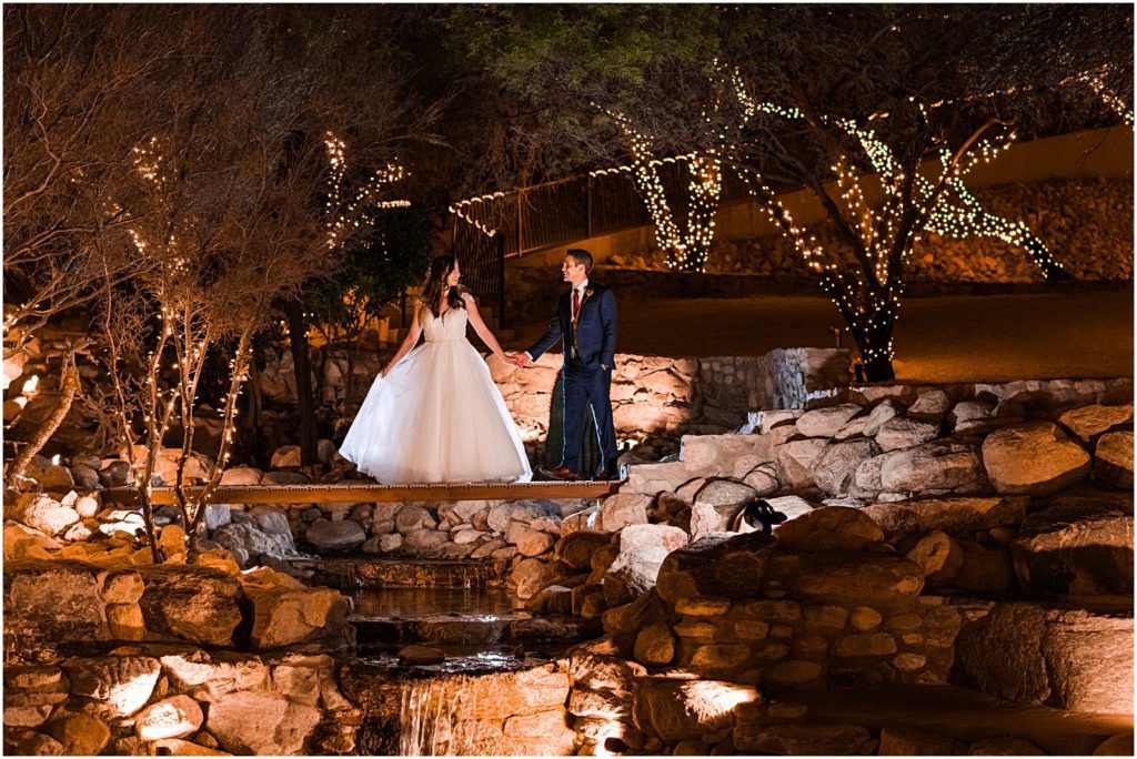 nighttime portrait on bridge over pond surrounded by twinkle lights