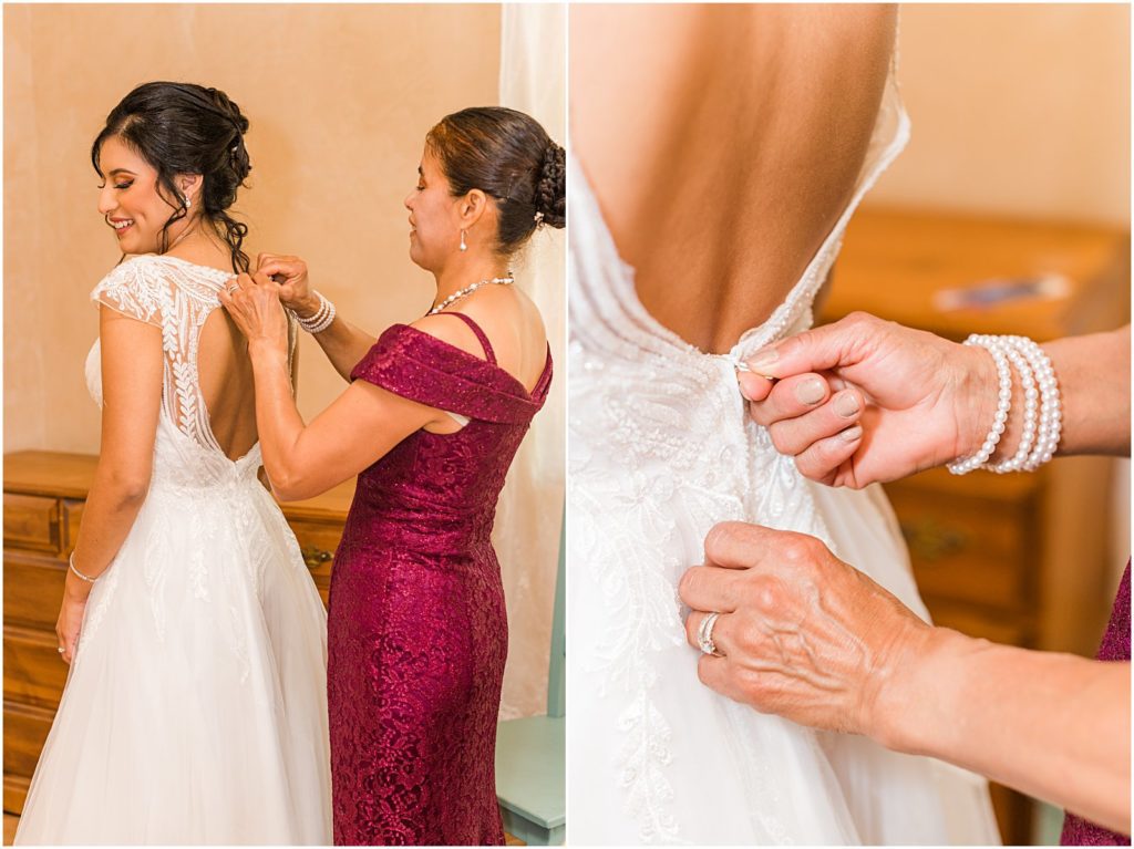 bride's mom zipping up daughter in wedding dress