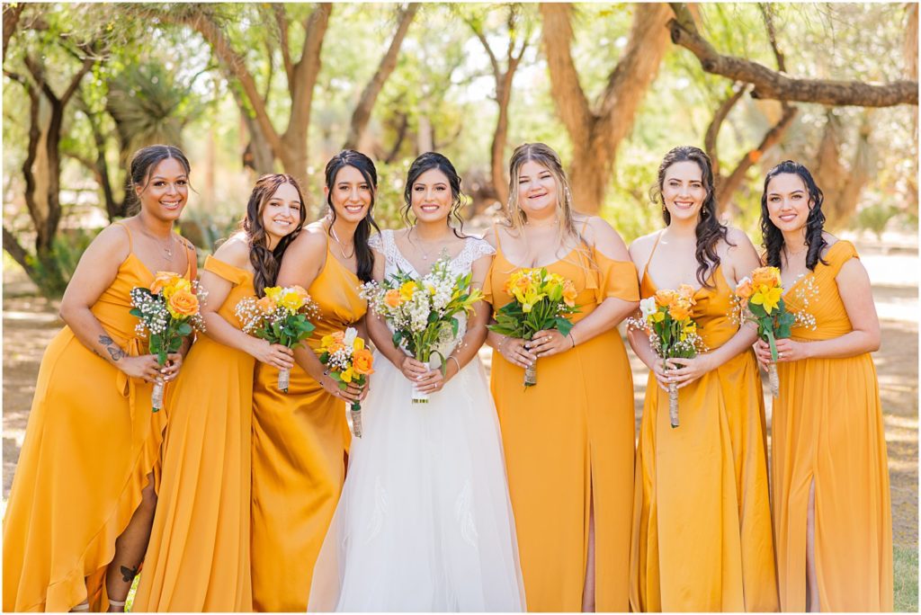 bride with bridesmaids wearing matching marigold yellow dresses