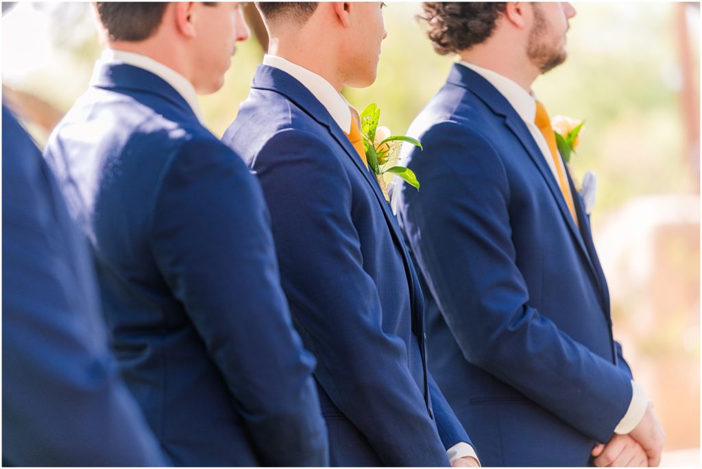 groomsmen in navy suits standing during ceremony
