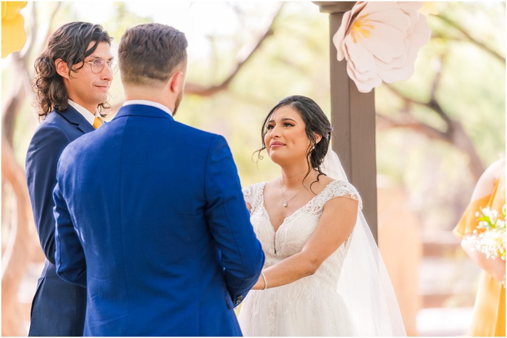 bride holding back tears while listening to vows