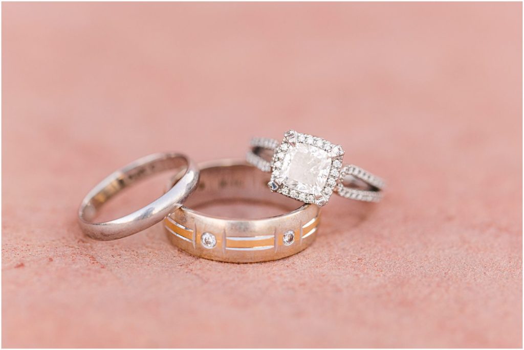 photo of wedding bands and large diamond engagement ring on red rock bench