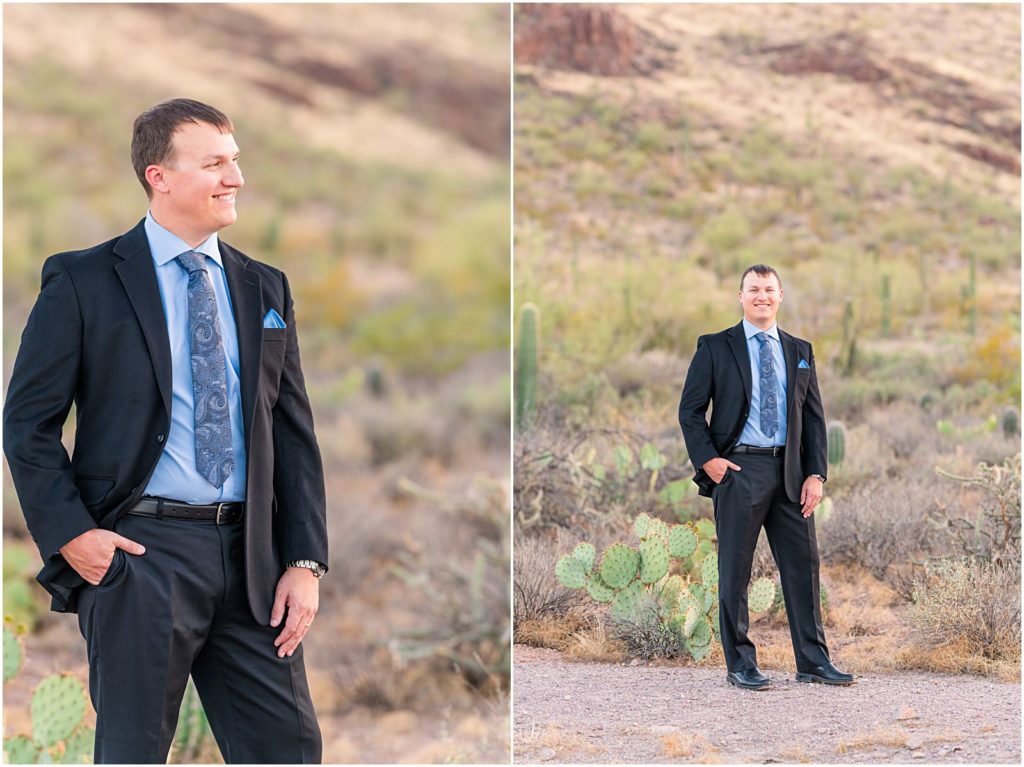 guy wearing black suit with blue shirt and tie standing in desert