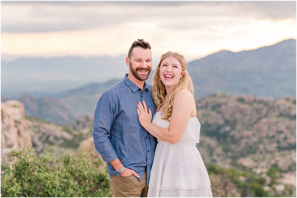 engaged couple laughing with mountains behind them