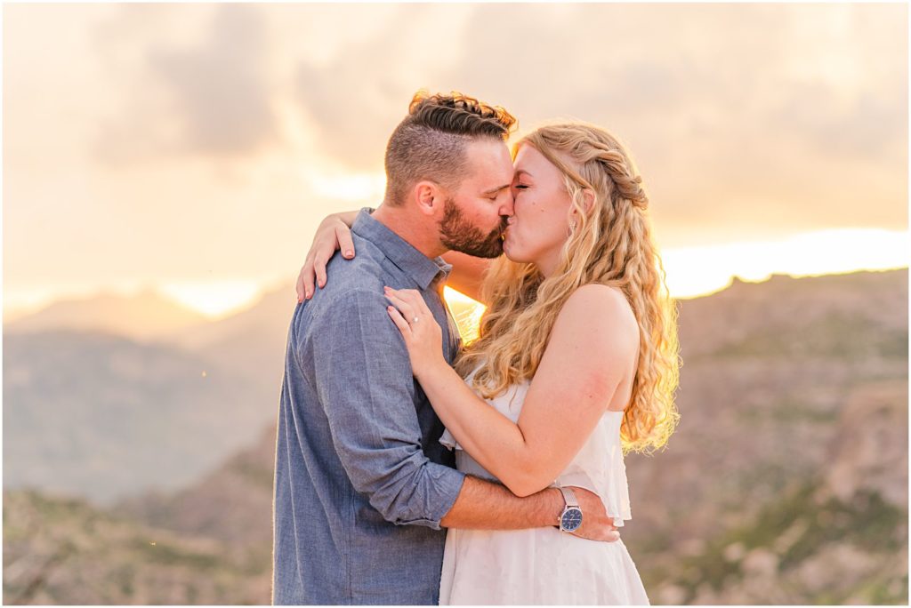 couple kissing at sunset on mountaintop