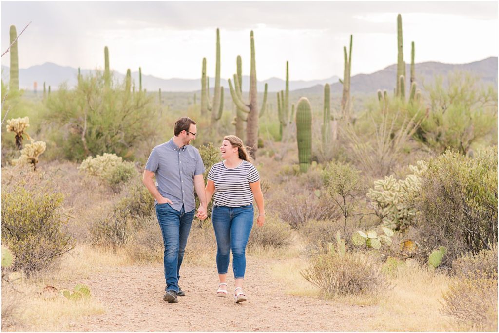 couple laughing and walking together in desert