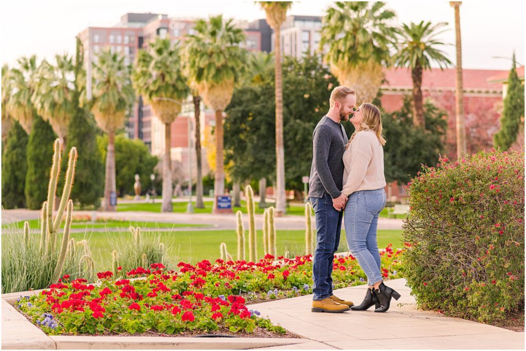 engaged couple kissing by water fountain at the University of Arizona