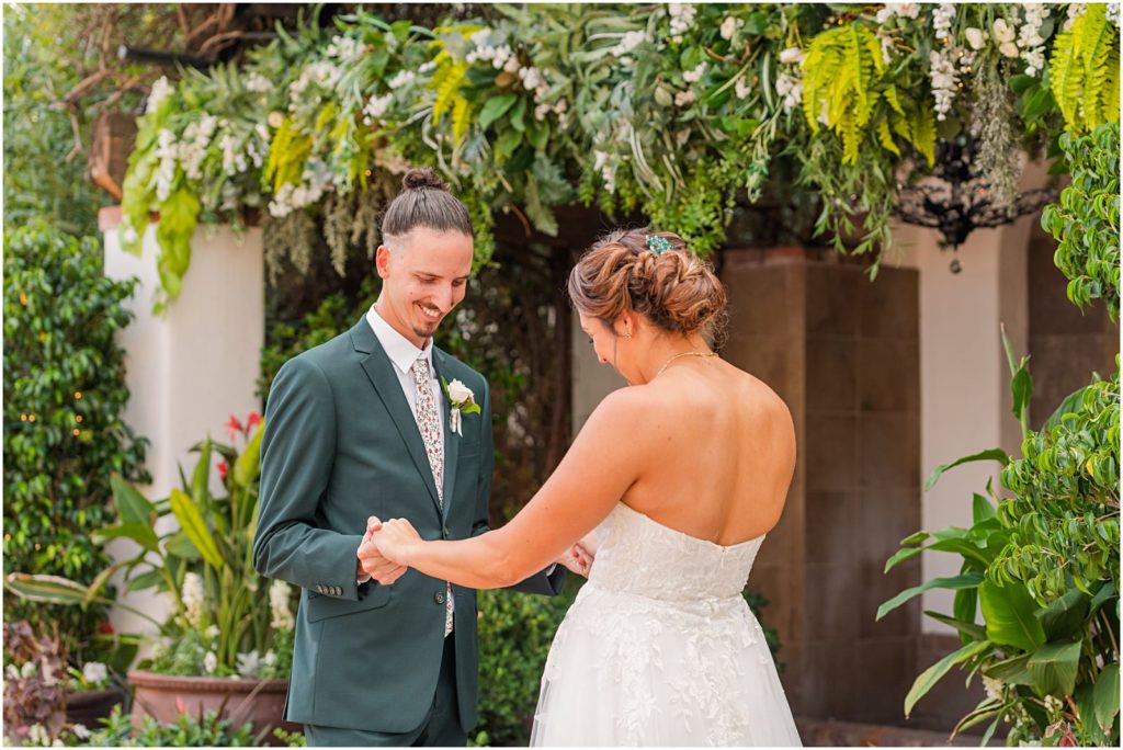 groom looks at his bride in her wedding dress