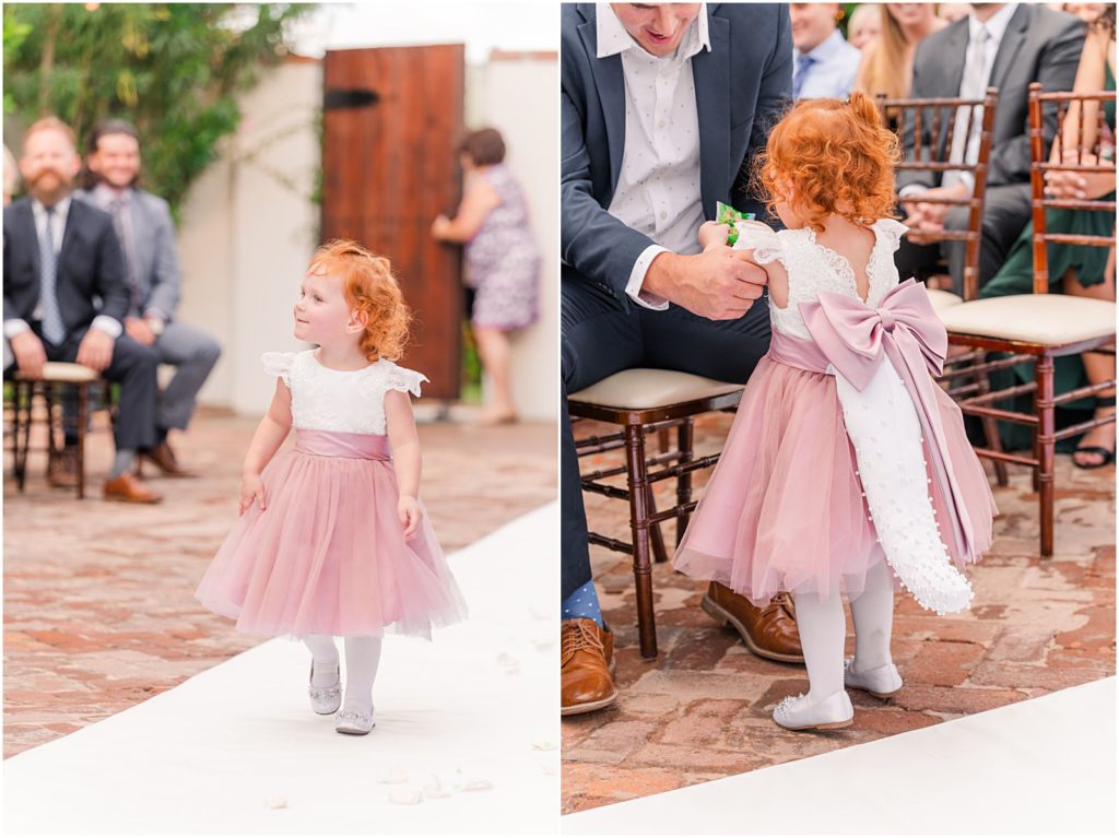 red headed flower girl wearing pink dress with dinosaur tail