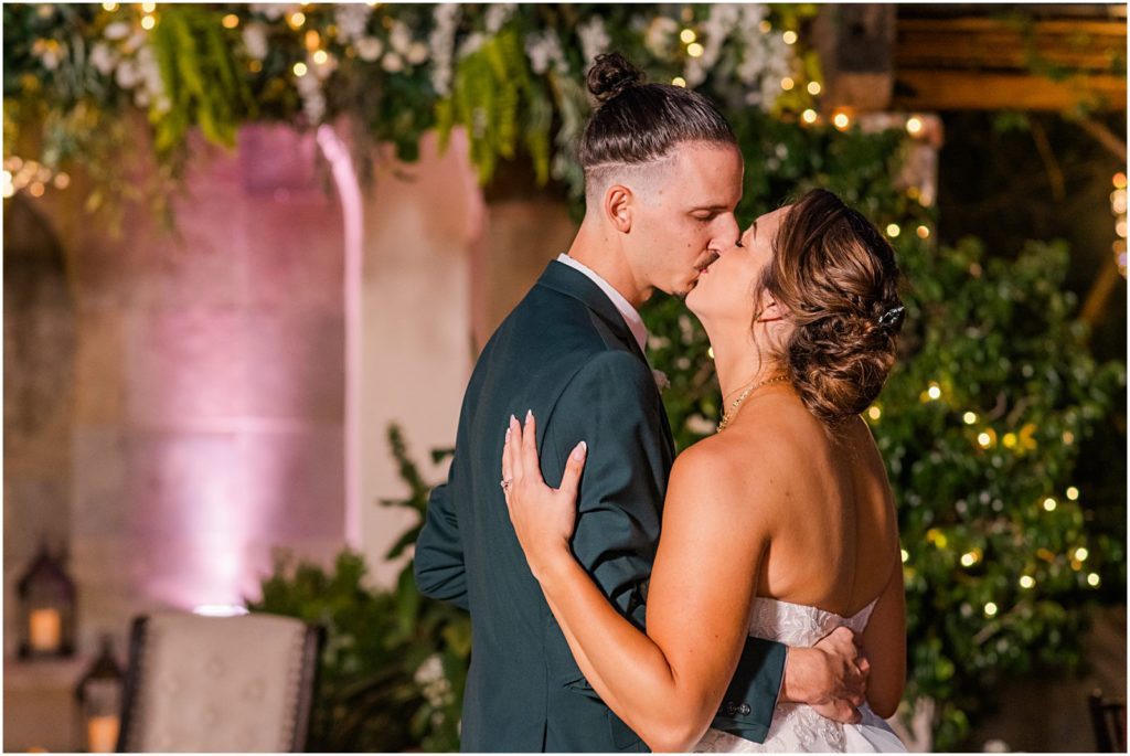 bride and groom kiss during first dance at wedding reception