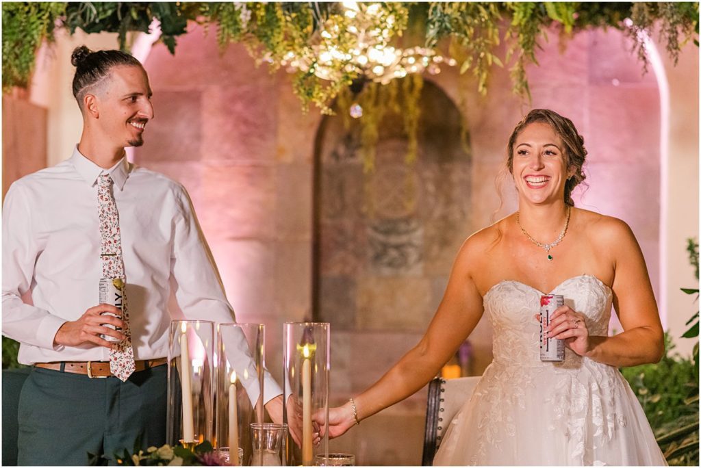 bride and groom standing behind sweetheart table