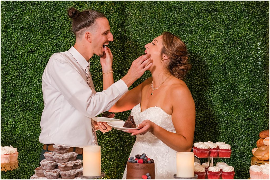 groom and bride feed each other wedding cake