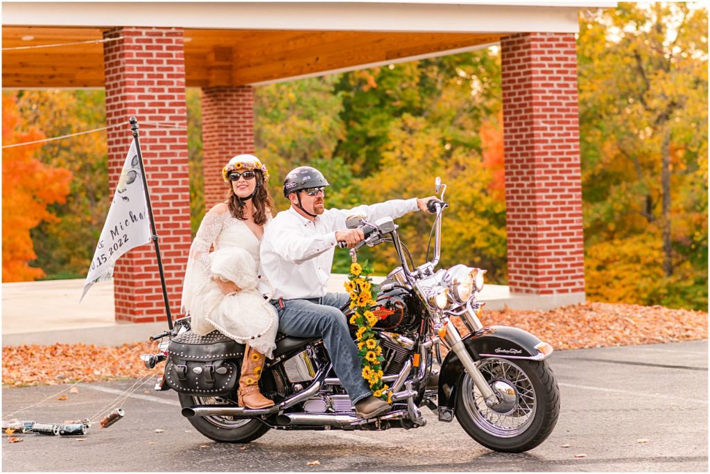 bride and groom drive to reception on motorcycle