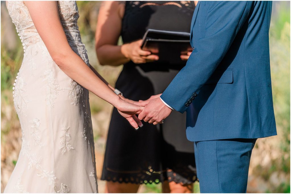 couple holding hands during wedding ceremony