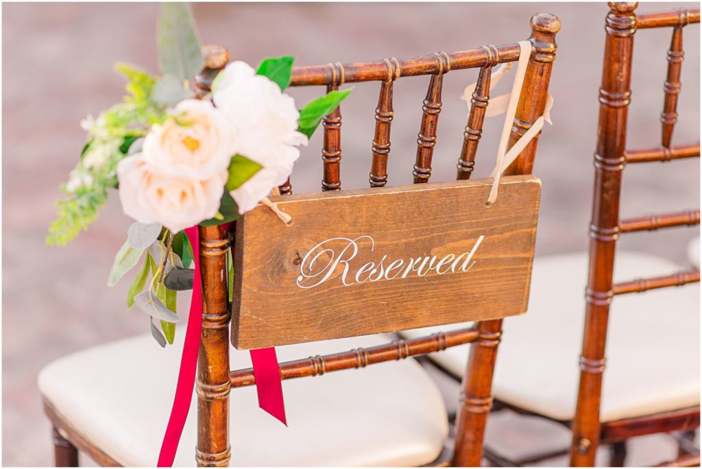 wooden cushioned chair with simple wooden "reserved" sign