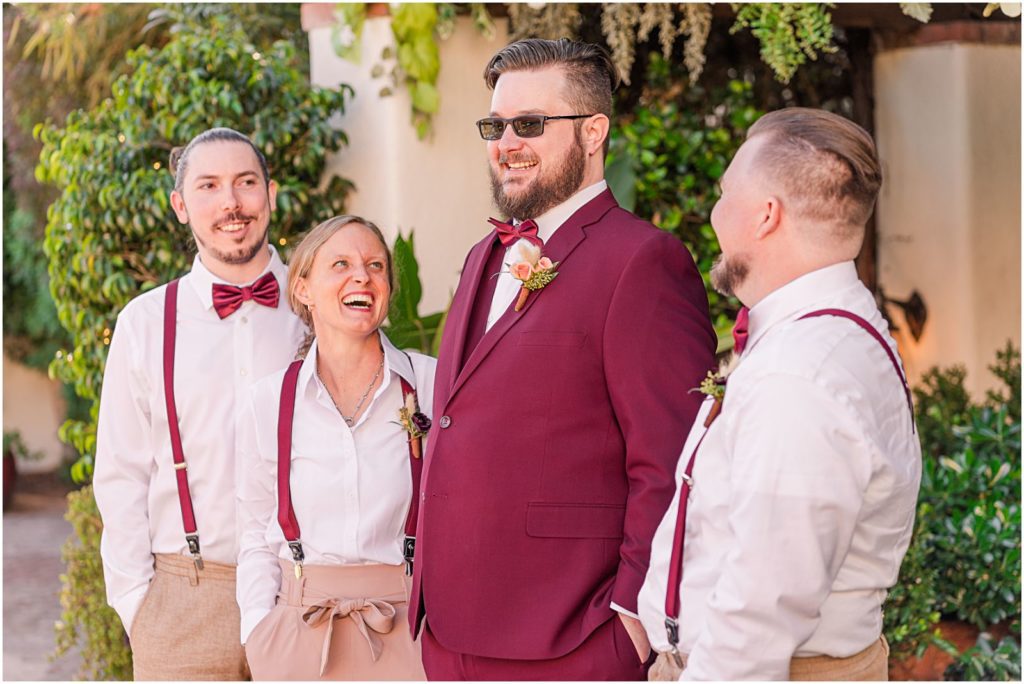 groomsmen and groomswoman smiling at groom