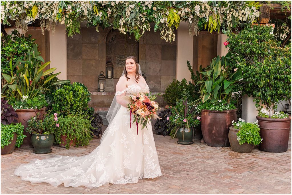 photo of bride in courtyard smiling to the groom off-camera