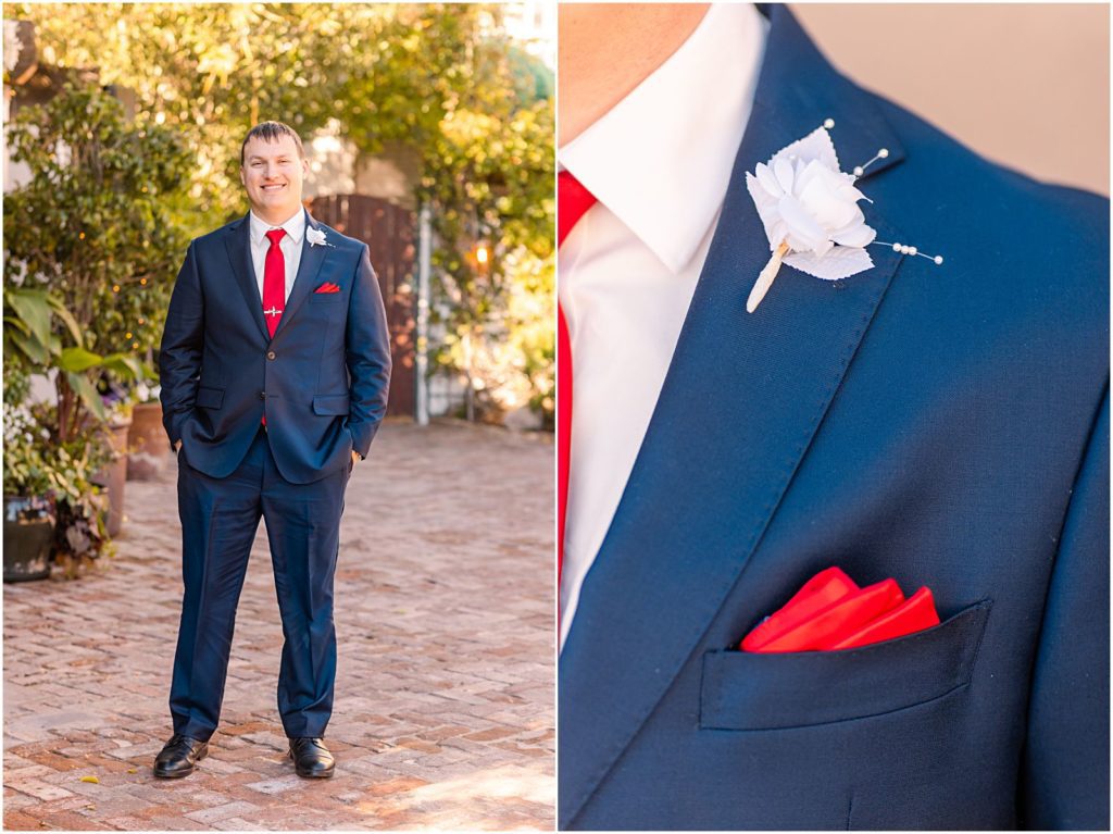 portrait of groom in navy suit with red tie and pocket square