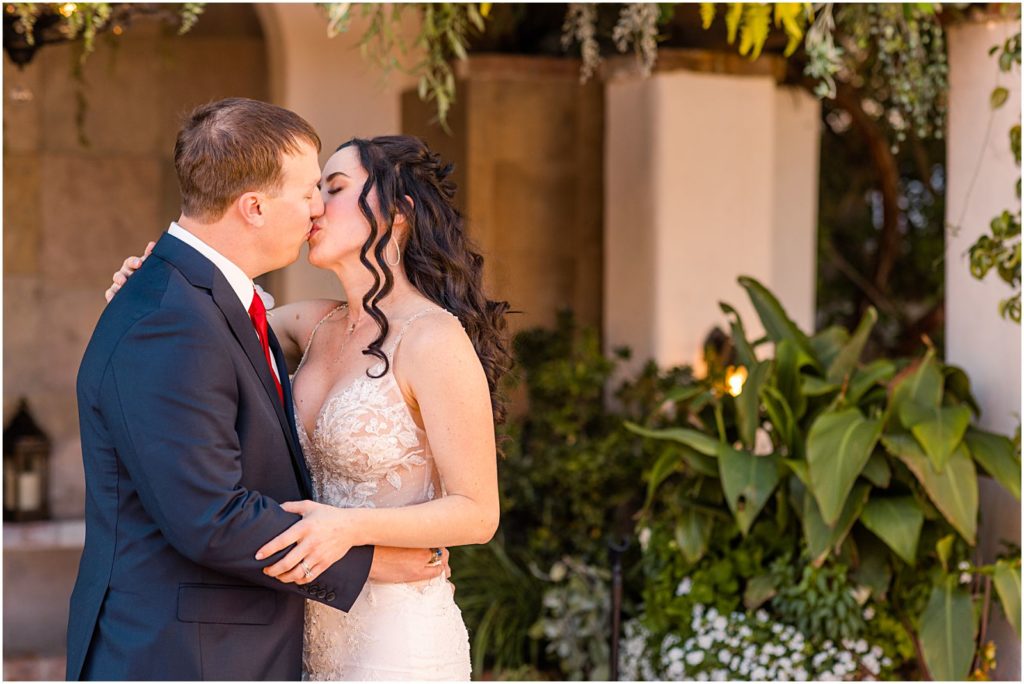 bride and groom kissing in garden courtyard