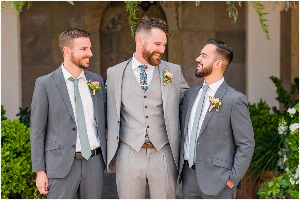 groom laughing with his two groomsmen