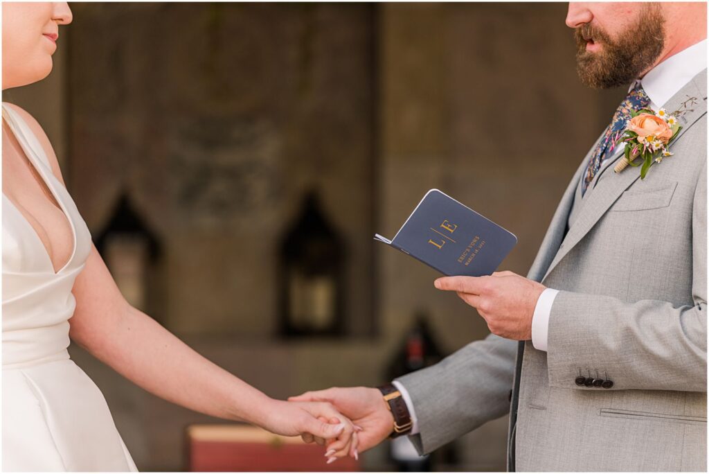 couple holding hands while reading vows to each other