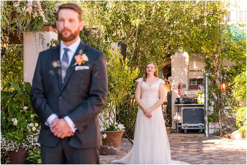 bride standing behind groom at First Look