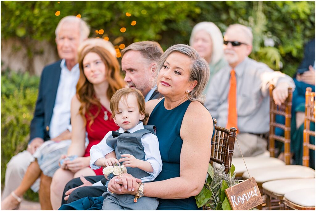 groom's mom watching ceremony and holding young nephew