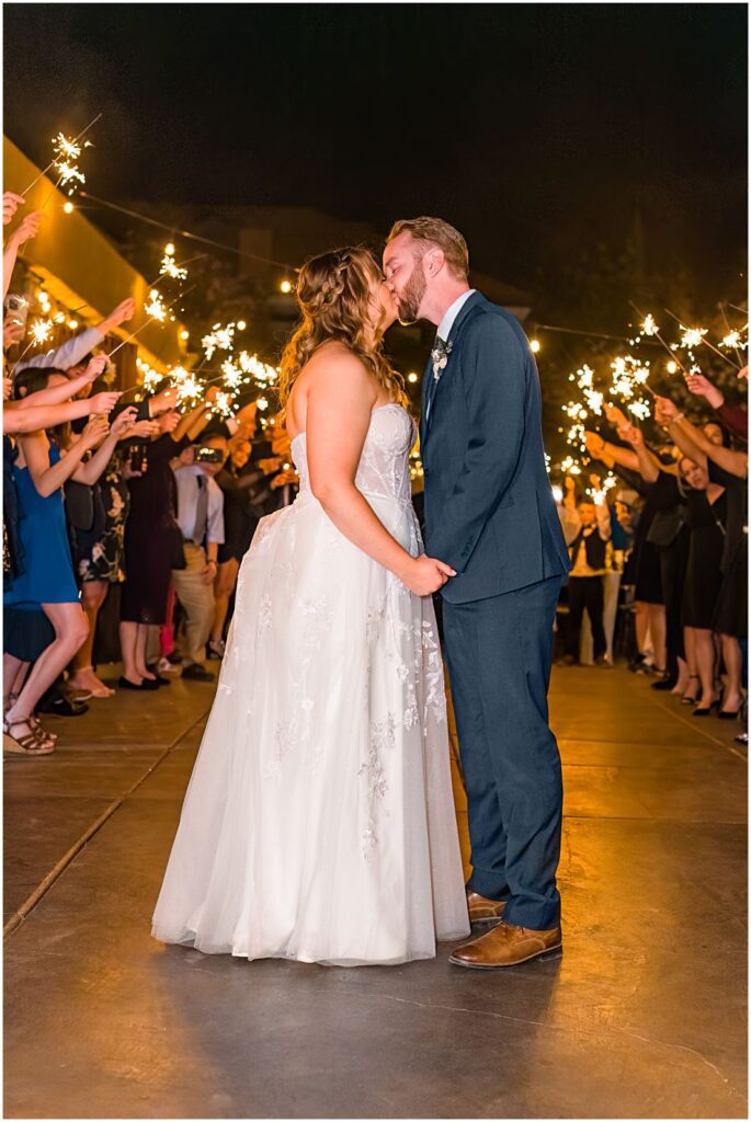 couple kissing while surrounded by sparklers at night